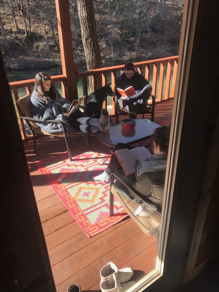 Reading on the balcony of our cozy cabin in Mountain View, Arkansas.