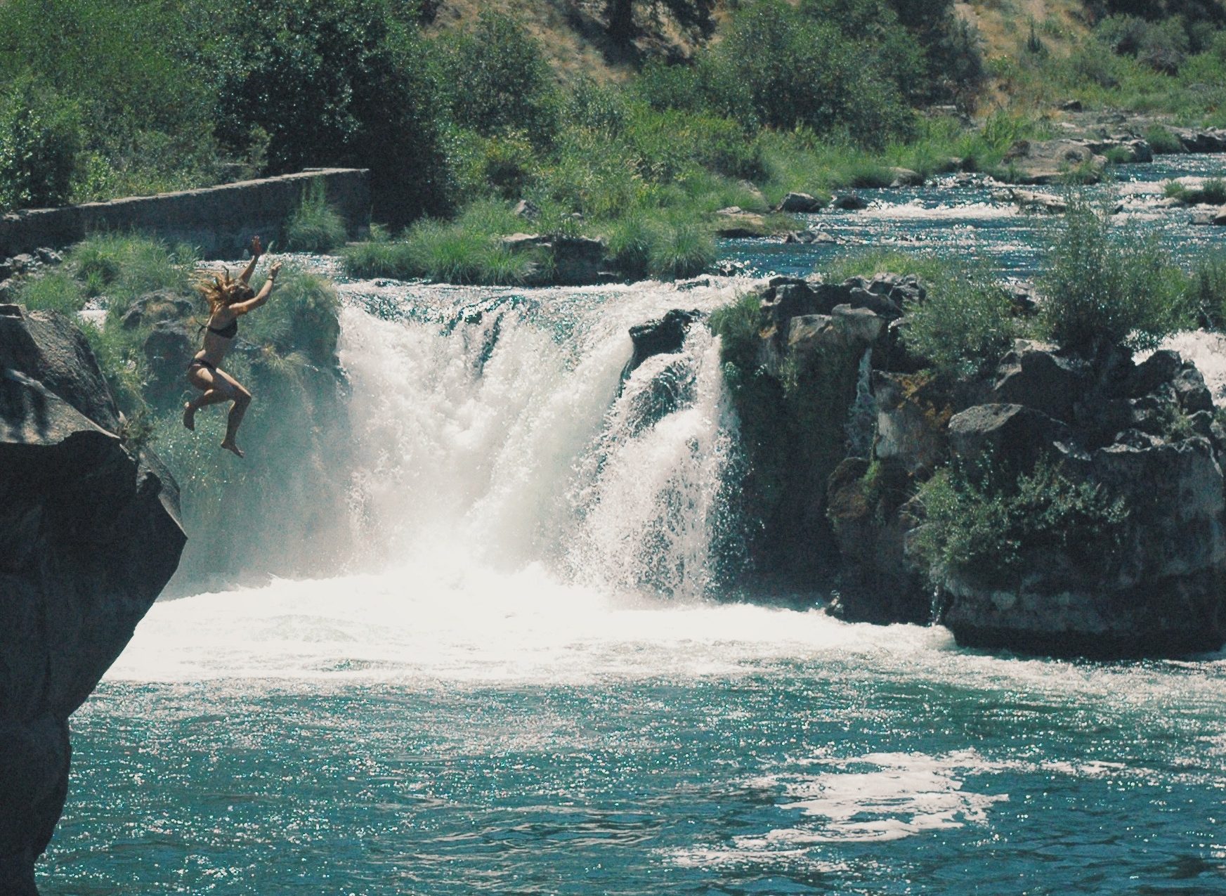 Naomi cliff jumping near a waterfall. Sometimes you've got to leap!