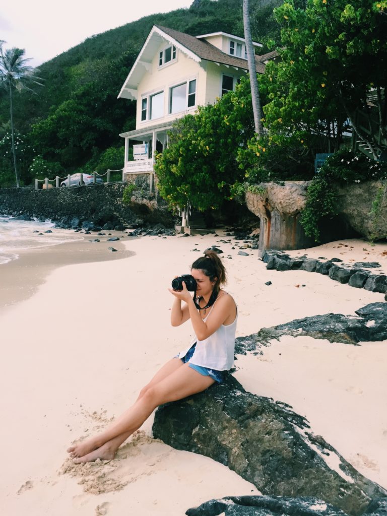 Photographer framing a shot at the beach.